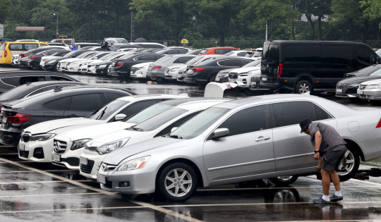 11일 오후 경기도 과천 서울대공원 주차장에 마련된 한 손해보험사 임시 보상서비스센터에 연일 내린 집중호우에 침수 피해를 입은 차량들이 주차되어 있다. 연합뉴스.